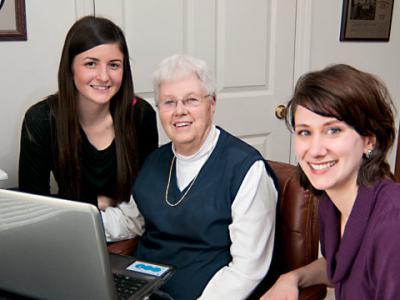 Penn State students Amanda Gresh (left) and Courtney Polenick (right) help Annetta Pierce (middle), a resident at The Village at Penn State, learn to Skype.-Older adults learn to Skype with help from Penn State students 