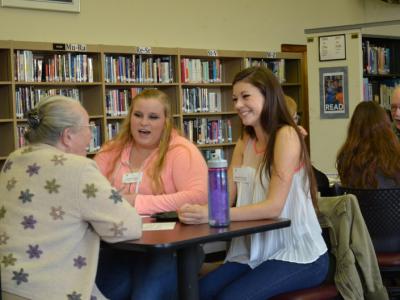 12th graders Jen Veltri and Hannah Brewster in deep conversation with Marcia Beppler, retired Penn State 4-H Program Leader. Art Goldschmidt, Penn State Professor Emeritus of Middle East History, and his group are in the background.-Intergenerational Conversations: The Kite Runner Program